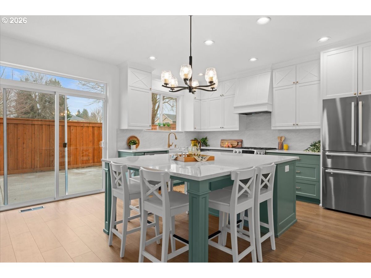 11595 Southwest Butte Lane Beaverton, OR 97008 - Photo 3 of 48 a kitchen with stainless steel appliances kitchen island granite countertop a dining table chairs and granite counter tops