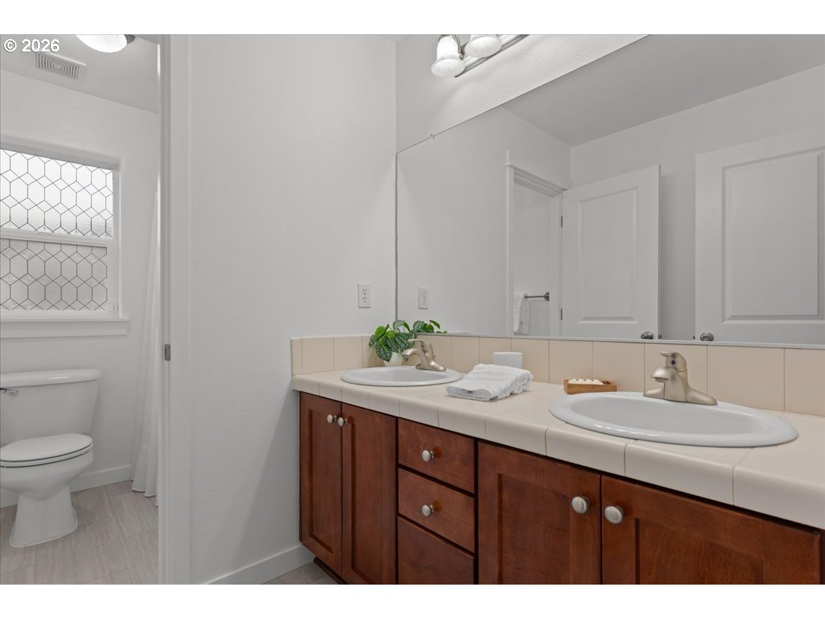 11595 Southwest Butte Lane Beaverton, OR 97008 - Photo 34 of 48 a bathroom with a granite countertop sink a toilet and a mirror