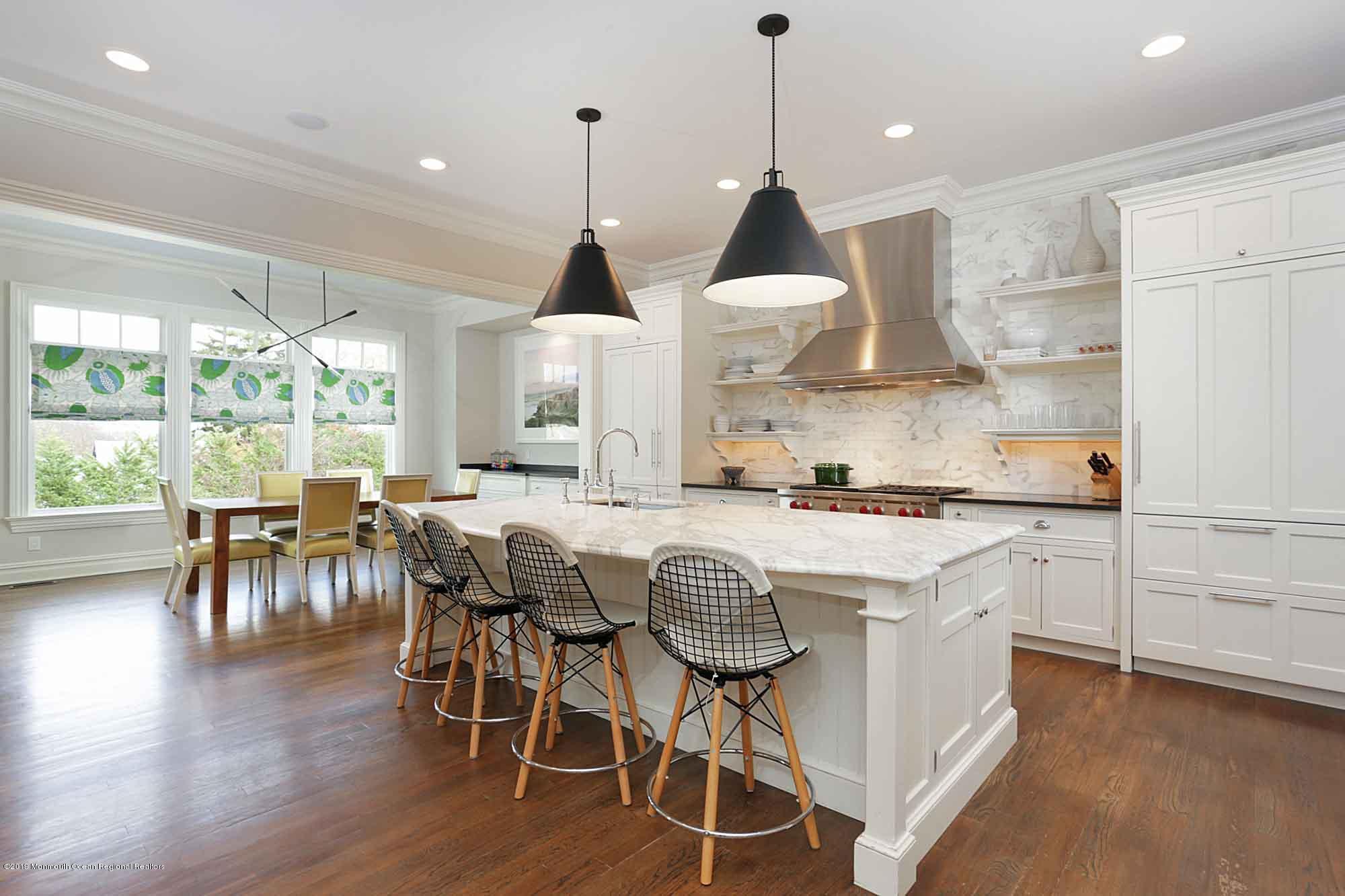 3 Sugar Maple Lane Rumson, NJ 07760 - Photo 10 of 33 a kitchen with stainless steel appliances granite countertop a stove a refrigerator a kitchen island a dining table and chairs with wooden floor