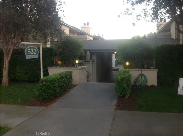 a front view of a house with a yard and green space