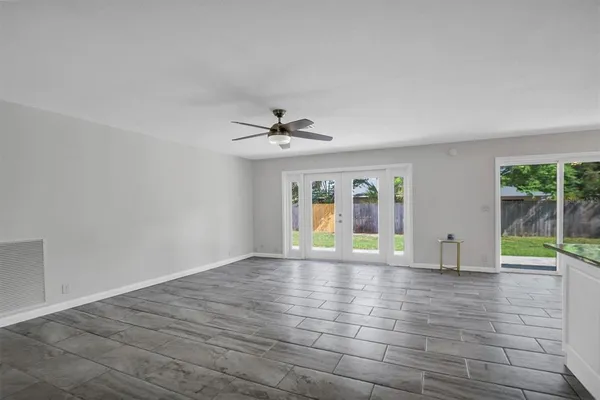 a view of an empty room with window and wooden floor