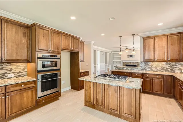 a kitchen with stainless steel appliances granite countertop a stove top oven a sink and a refrigerator