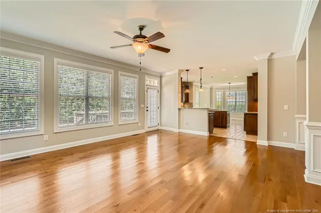 a view of an empty room with a window and wooden floor