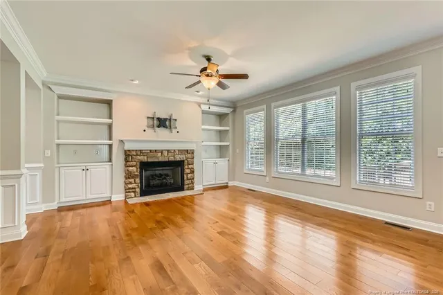 a view of an empty room with chandelier and fireplace