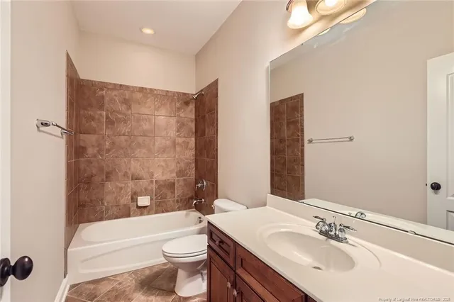 a bathroom with a bathtub shower sink mirror and toilet