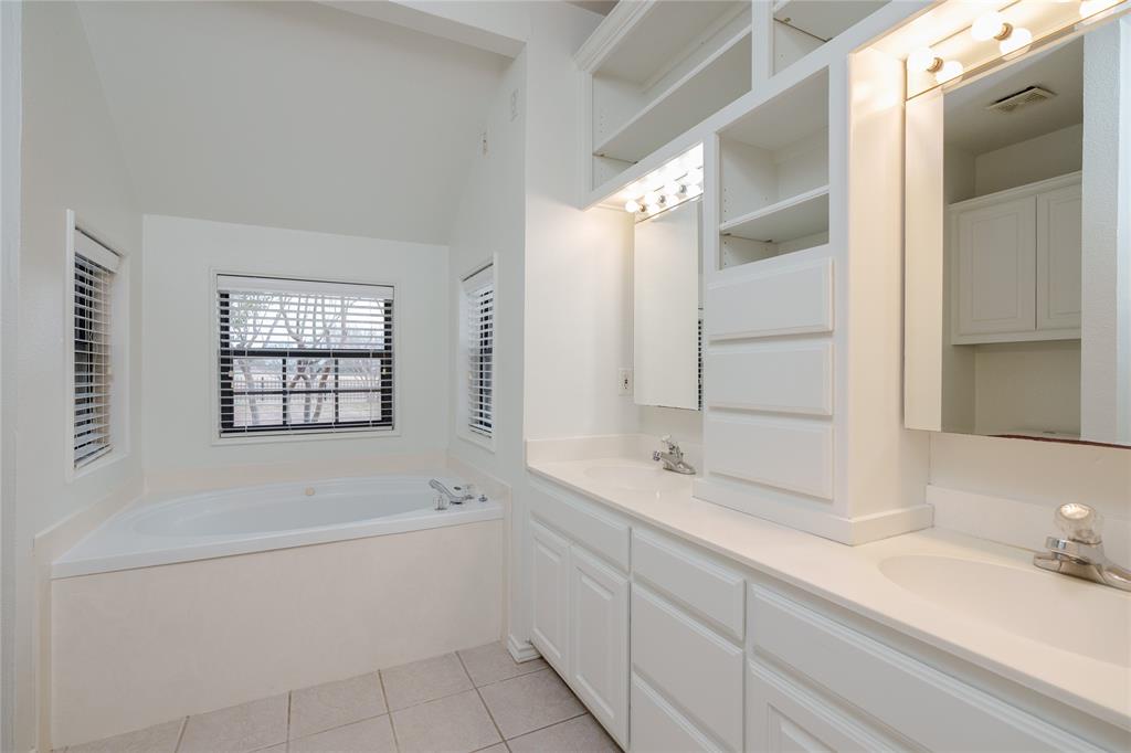 364 Parker Road, Unit A Van Alstyne, TX 75495 - Photo 22 of 39 featuring a soaking tub with surrounding windows, dual vanity sinks, white cabinetry, and overhead lighting fixtures