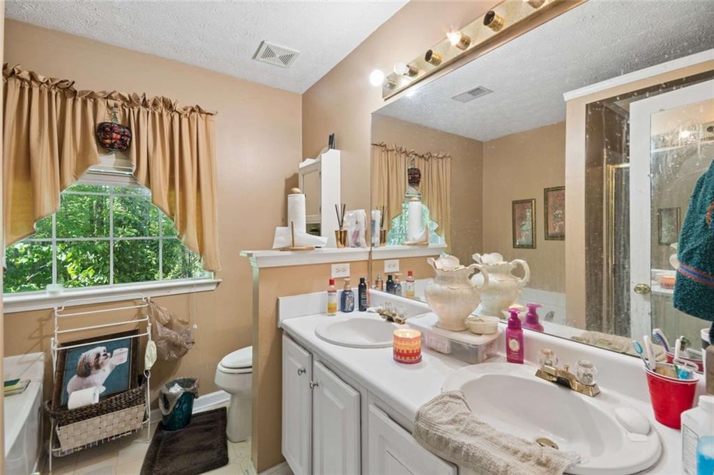4220 Arrowhead Pointe Austell, GA 30106 - Photo 13 of 20 a bathroom with a granite countertop sink a large mirror and a window