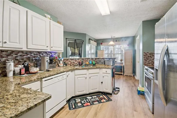 a kitchen with stainless steel appliances kitchen island granite countertop a sink stove and cabinets