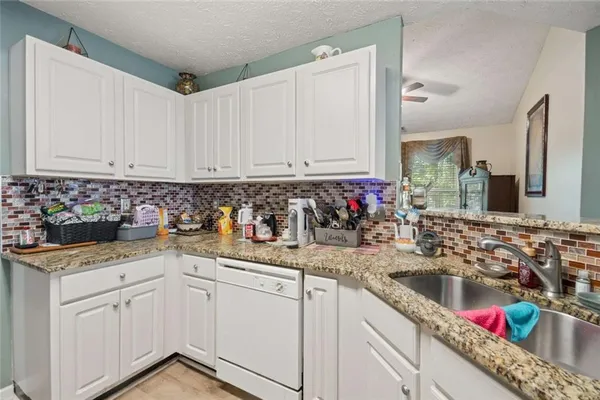 a kitchen with stainless steel appliances granite countertop a sink stove and cabinets