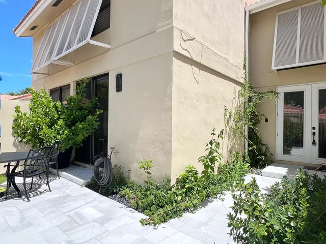 a view of a patio with table and chairs and potted plants
