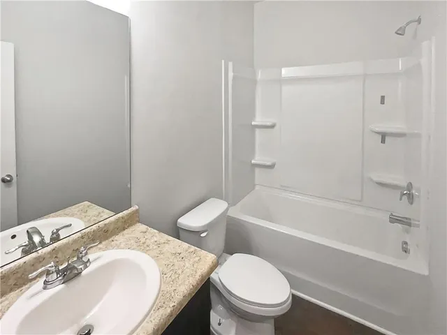 a bathroom with a granite countertop toilet a sink and bathtub