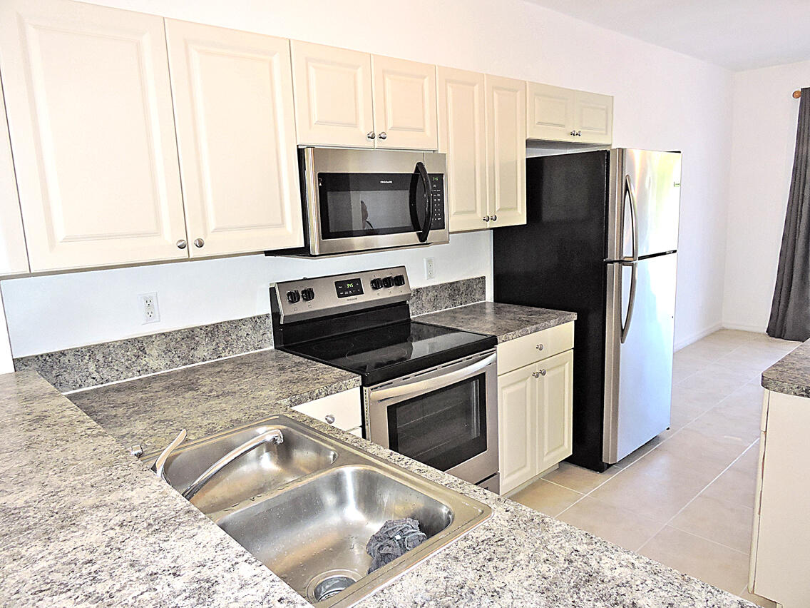 1986 Alamanda Way Riviera Beach, FL 33404 - Photo 11 of 49 a kitchen with stainless steel appliances granite countertop a refrigerator stove and microwave