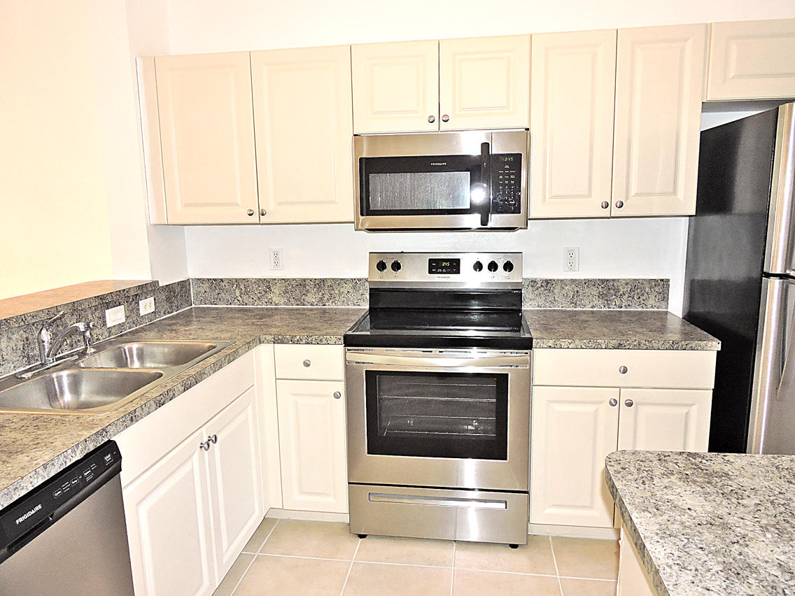 1986 Alamanda Way Riviera Beach, FL 33404 - Photo 13 of 49 a kitchen with stainless steel appliances granite countertop a stove microwave and refrigerator