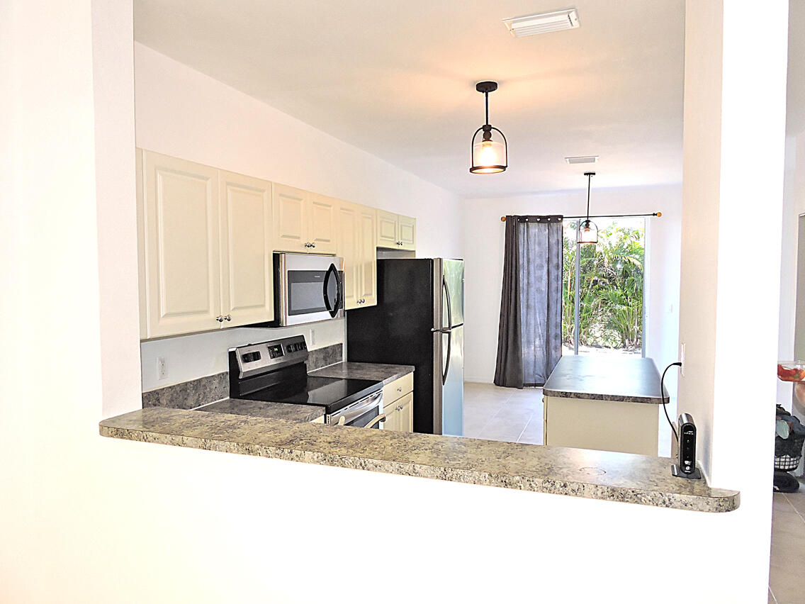 1986 Alamanda Way Riviera Beach, FL 33404 - Photo 10 of 49 a living room with stainless steel appliances kitchen island granite countertop furniture and a fireplace