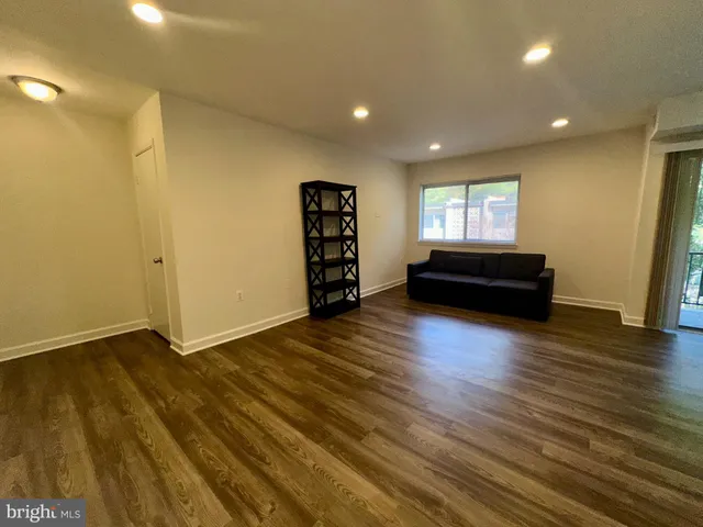 a view of a livingroom with wooden floor and a window