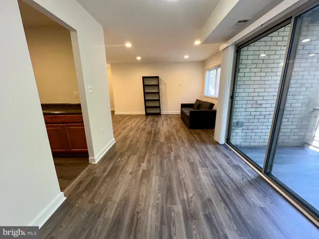 wooden floor in an empty room with a kitchen