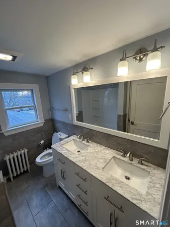 a bathroom with a double vanity sink and a mirror