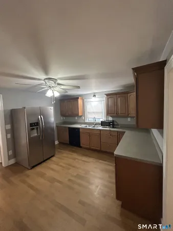 a kitchen with stainless steel appliances kitchen island granite countertop a refrigerator a sink a stove and oven