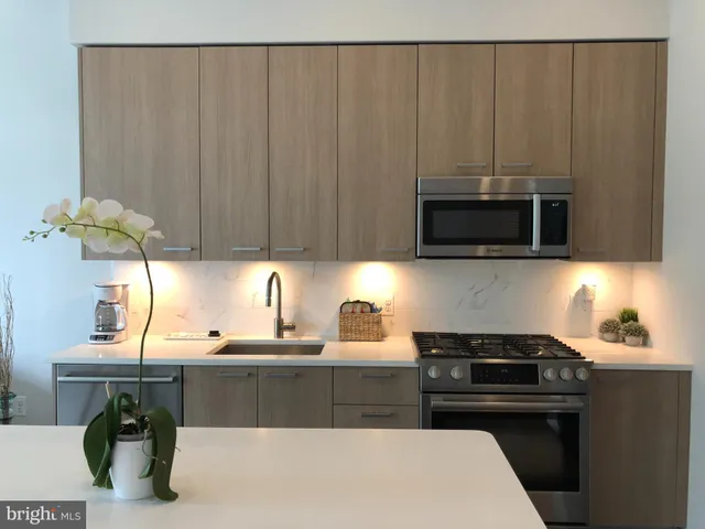 a kitchen with a sink a microwave and cabinets