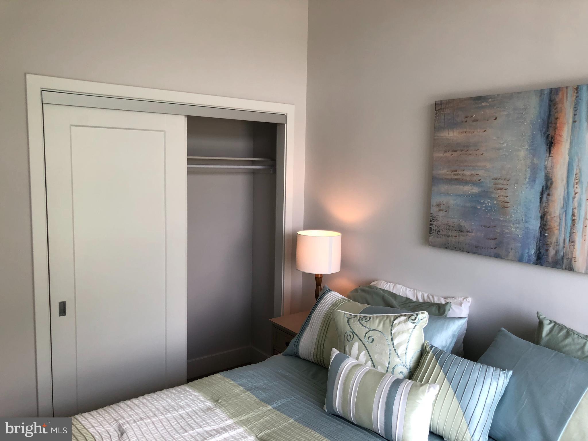 525 Water Street Southwest, Unit 308 Washington, DC 20024 - Photo 17 of 24 a bedroom with a bed and a mirror