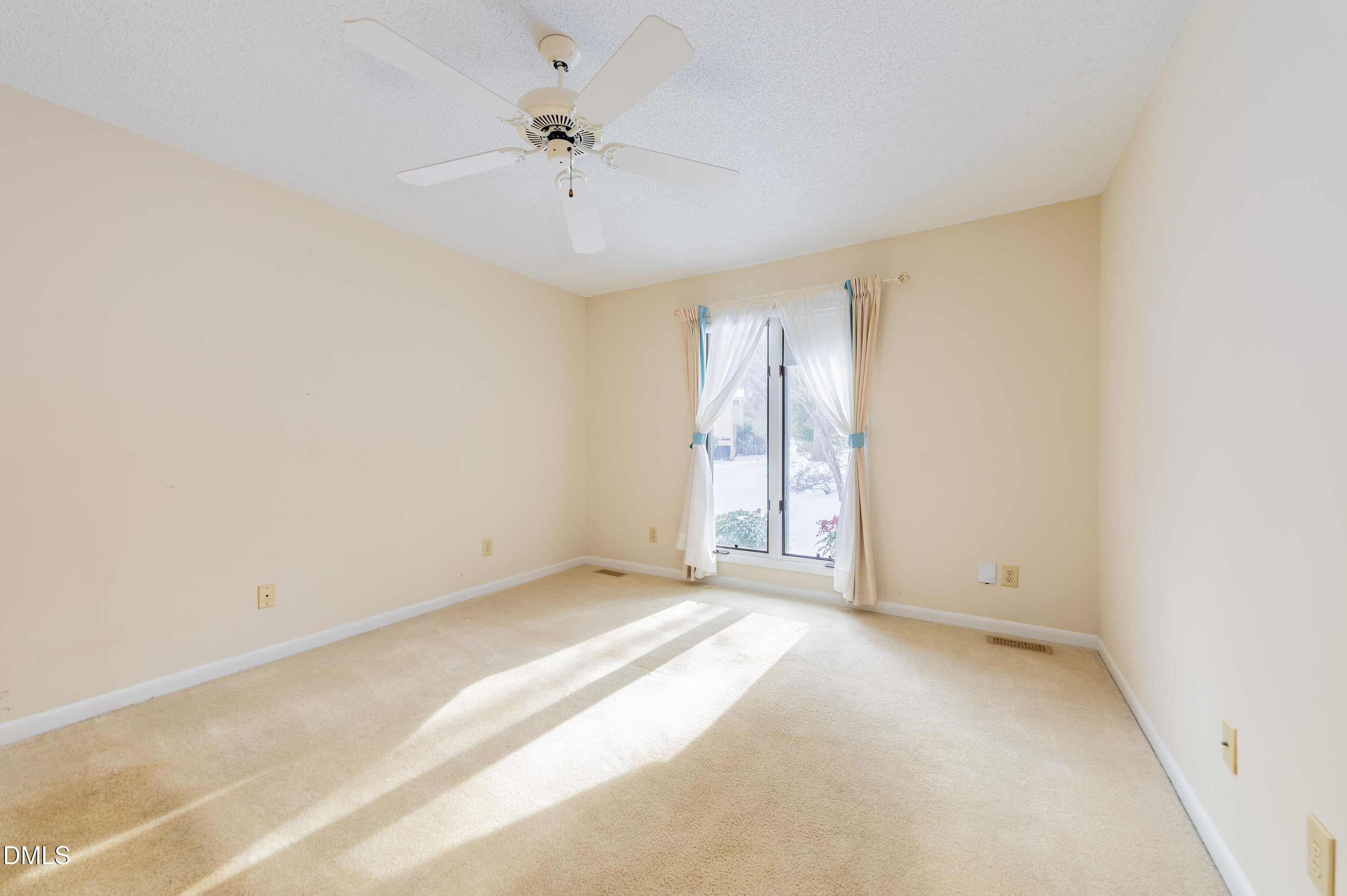 7918 Wood Cove Court Raleigh, NC 27615 - Photo 16 of 31 an empty room with chandelier fan and windows