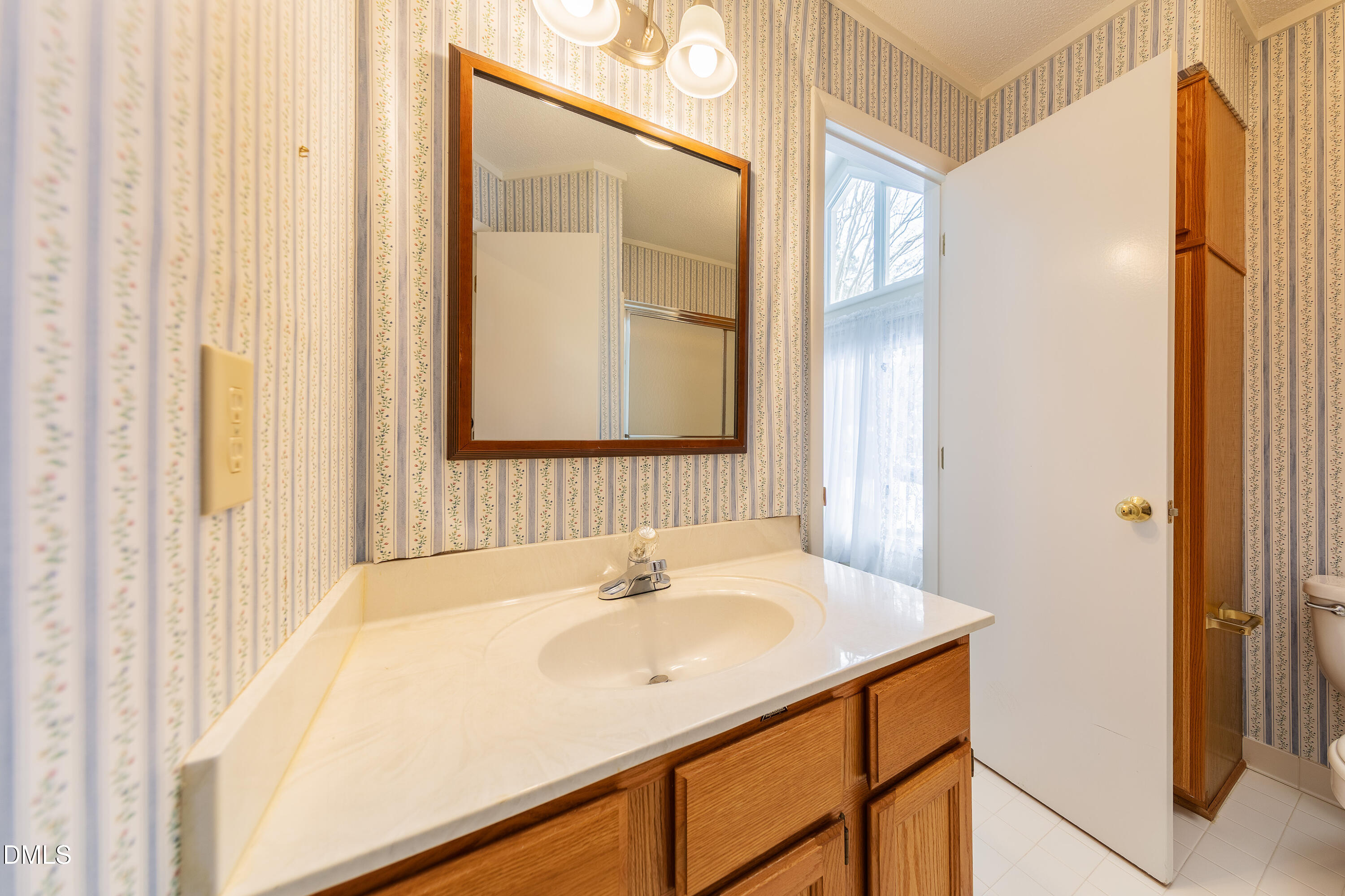7918 Wood Cove Court Raleigh, NC 27615 - Photo 24 of 31 a bathroom with a sink and a mirror