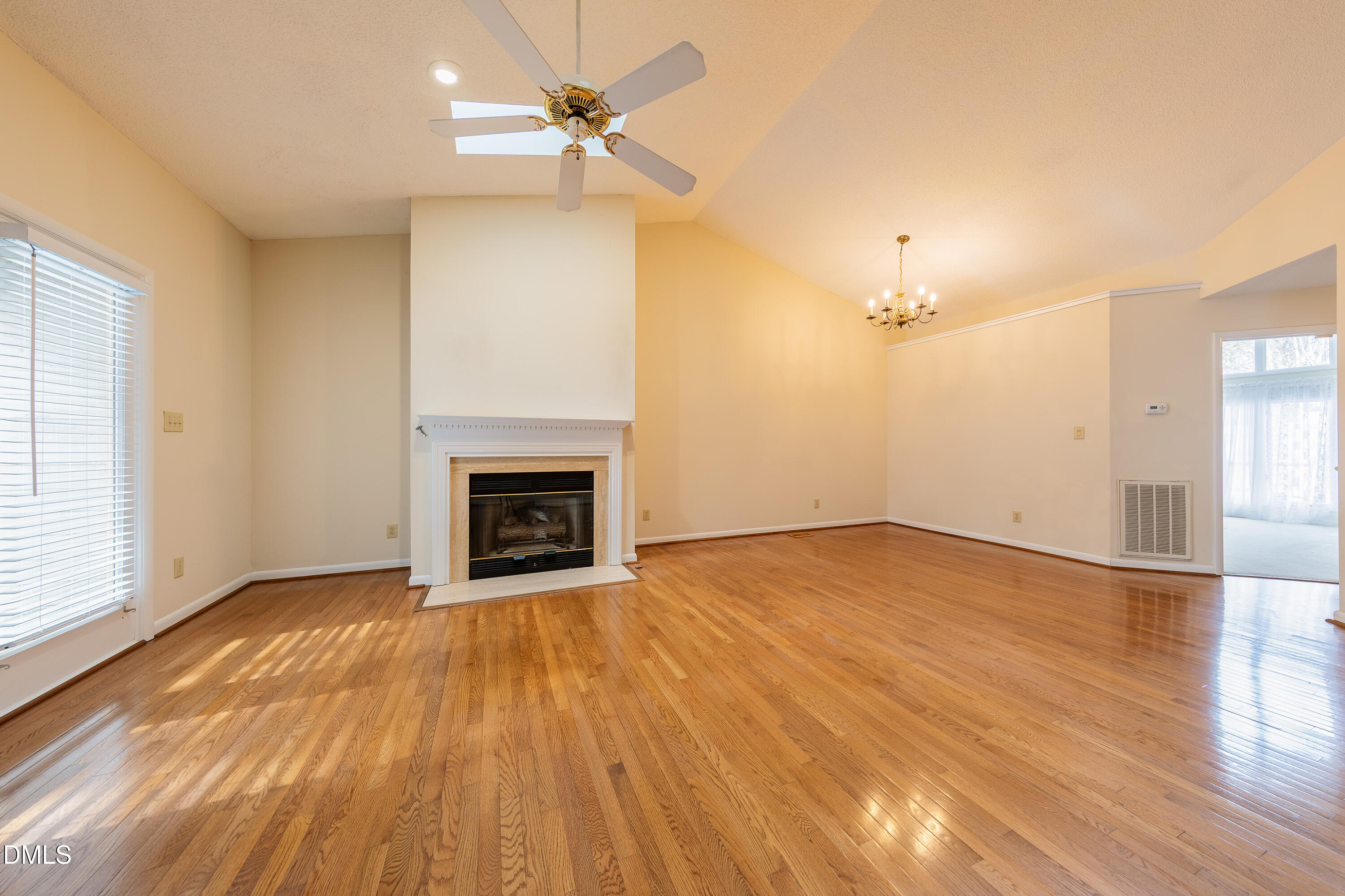 7918 Wood Cove Court Raleigh, NC 27615 - Photo 7 of 31 a view of empty room with wooden floor and fireplace
