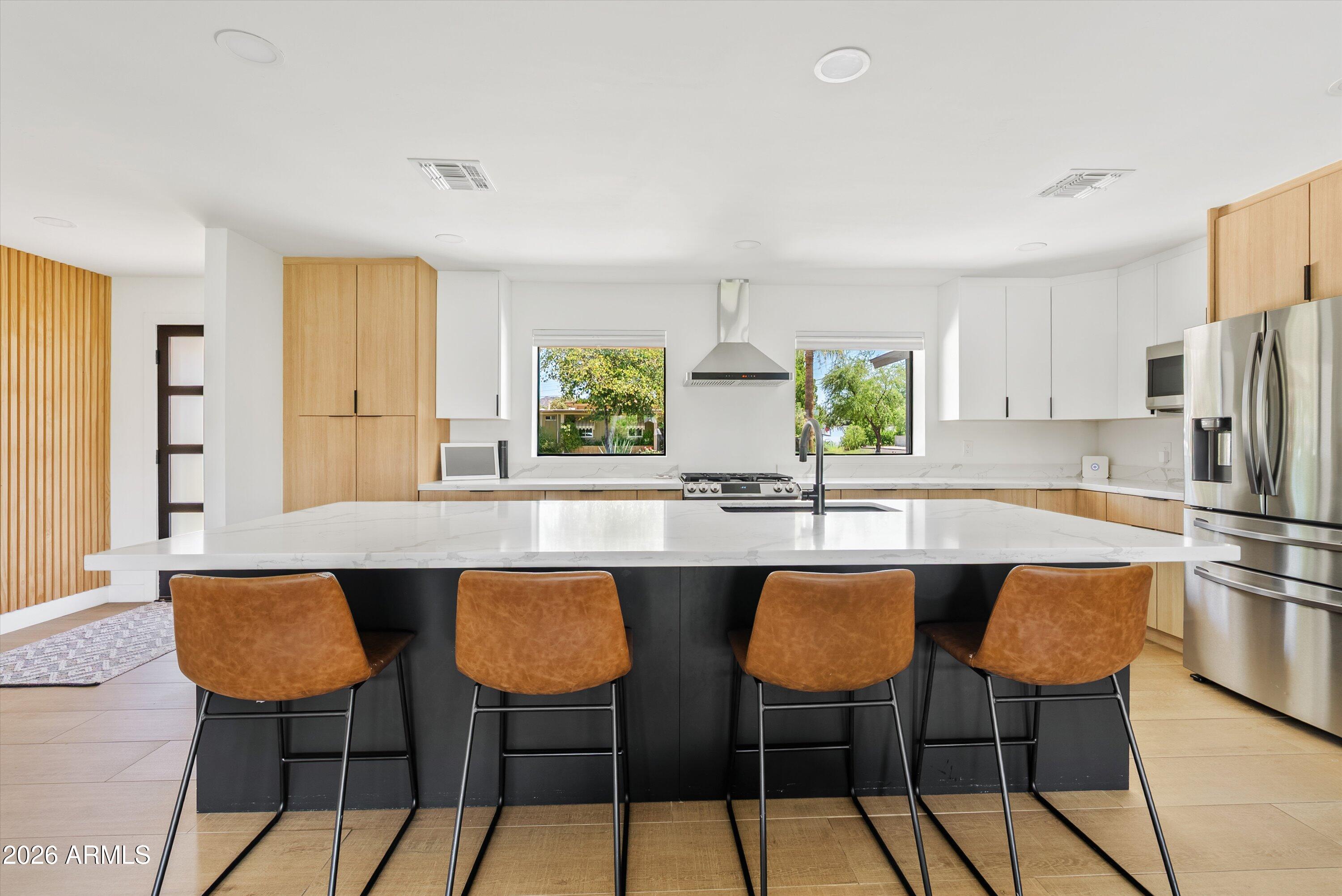 6706 North 12th Way Phoenix, AZ 85014 - Photo 3 of 39 a kitchen with stainless steel appliances a table and chairs in it