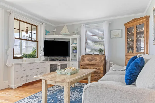 a living room with furniture a flat screen tv and a large window