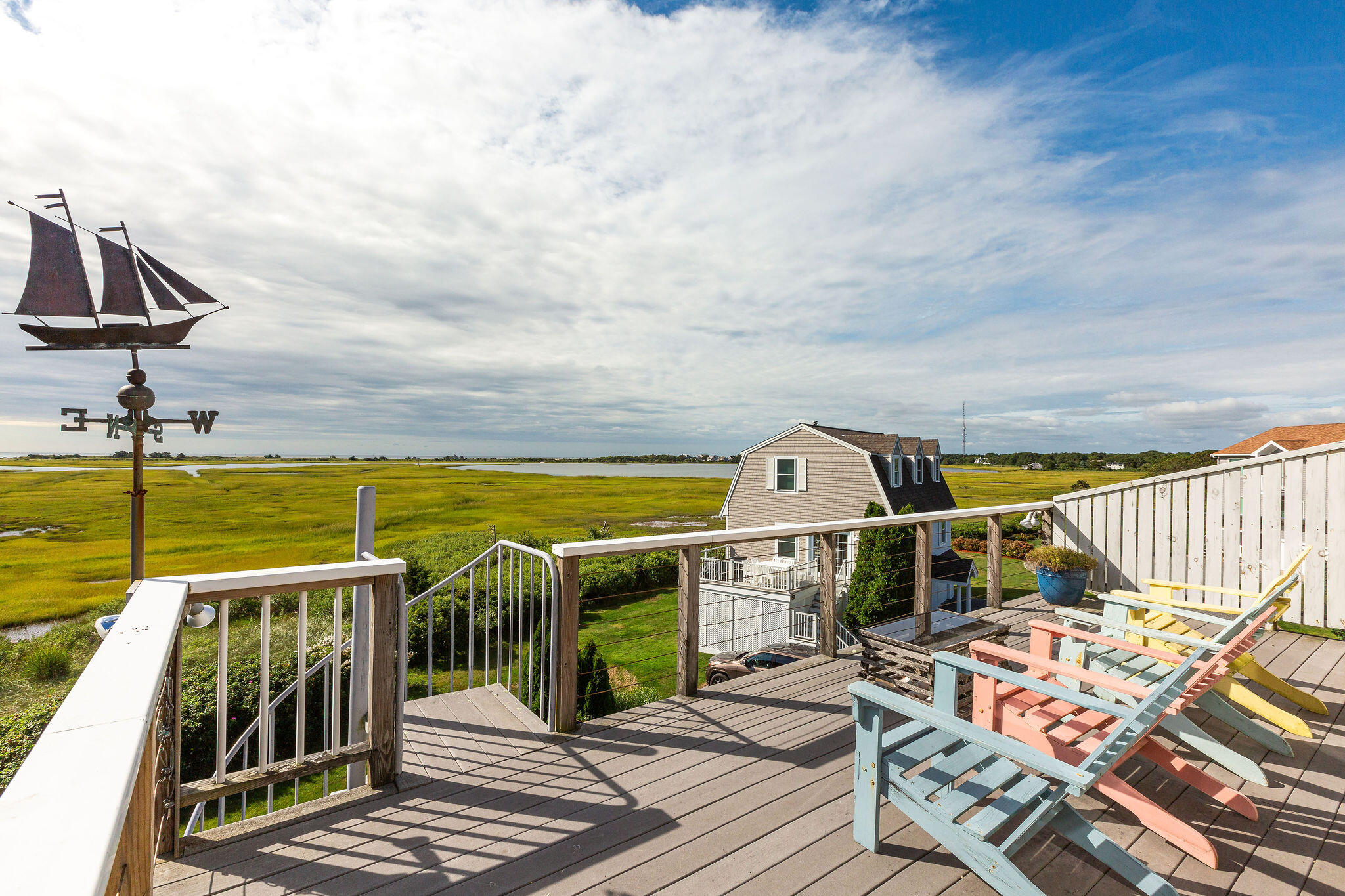 80 Mattakese Road, Unit 7 West Yarmouth, MA 02673 - Photo 28 of 38 a view of a balcony with two chairs and a potted plant on a table