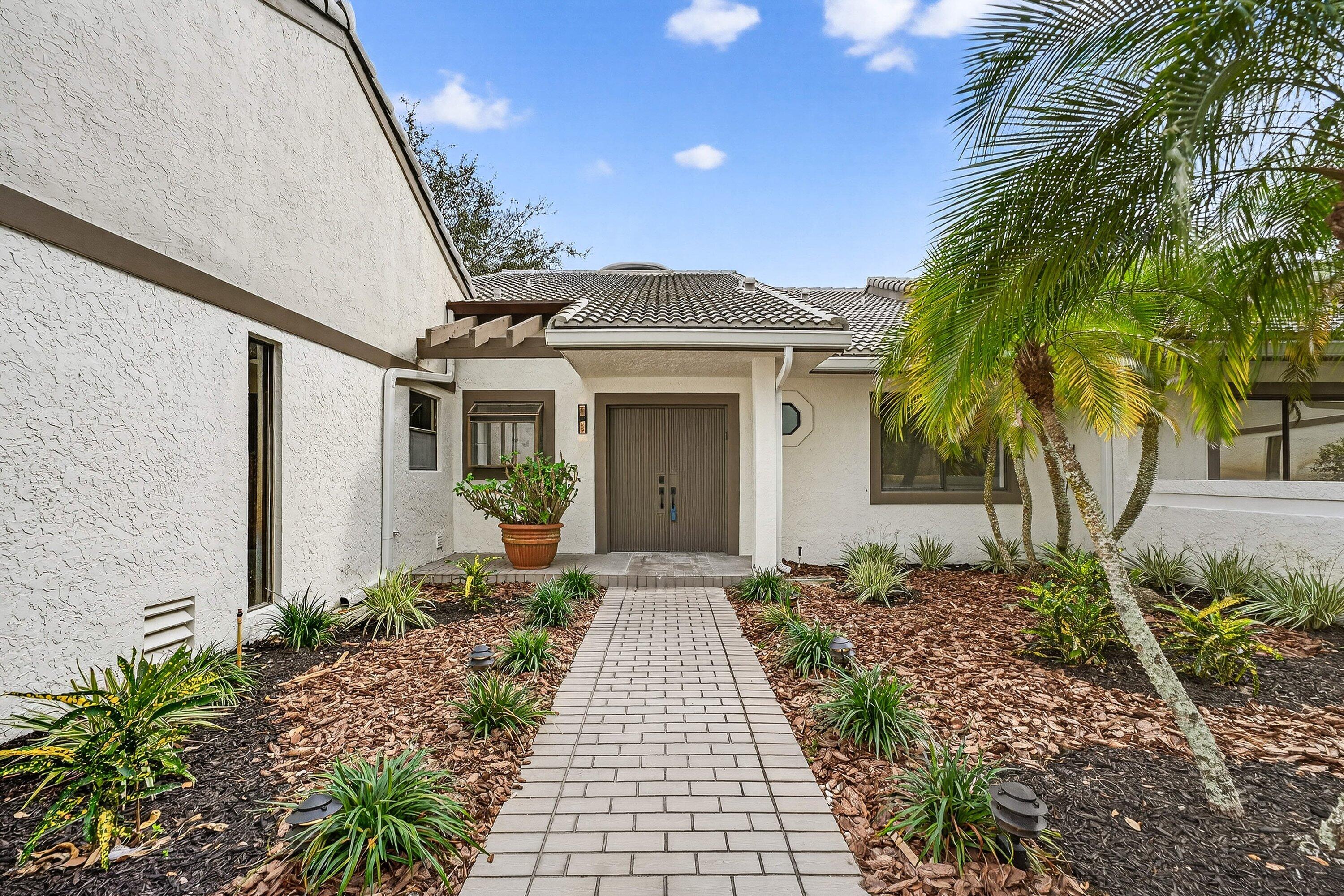 6 Clubhouse Lane Boynton Beach, FL 33436 - Photo 15 of 76 a front view of a house with a garden