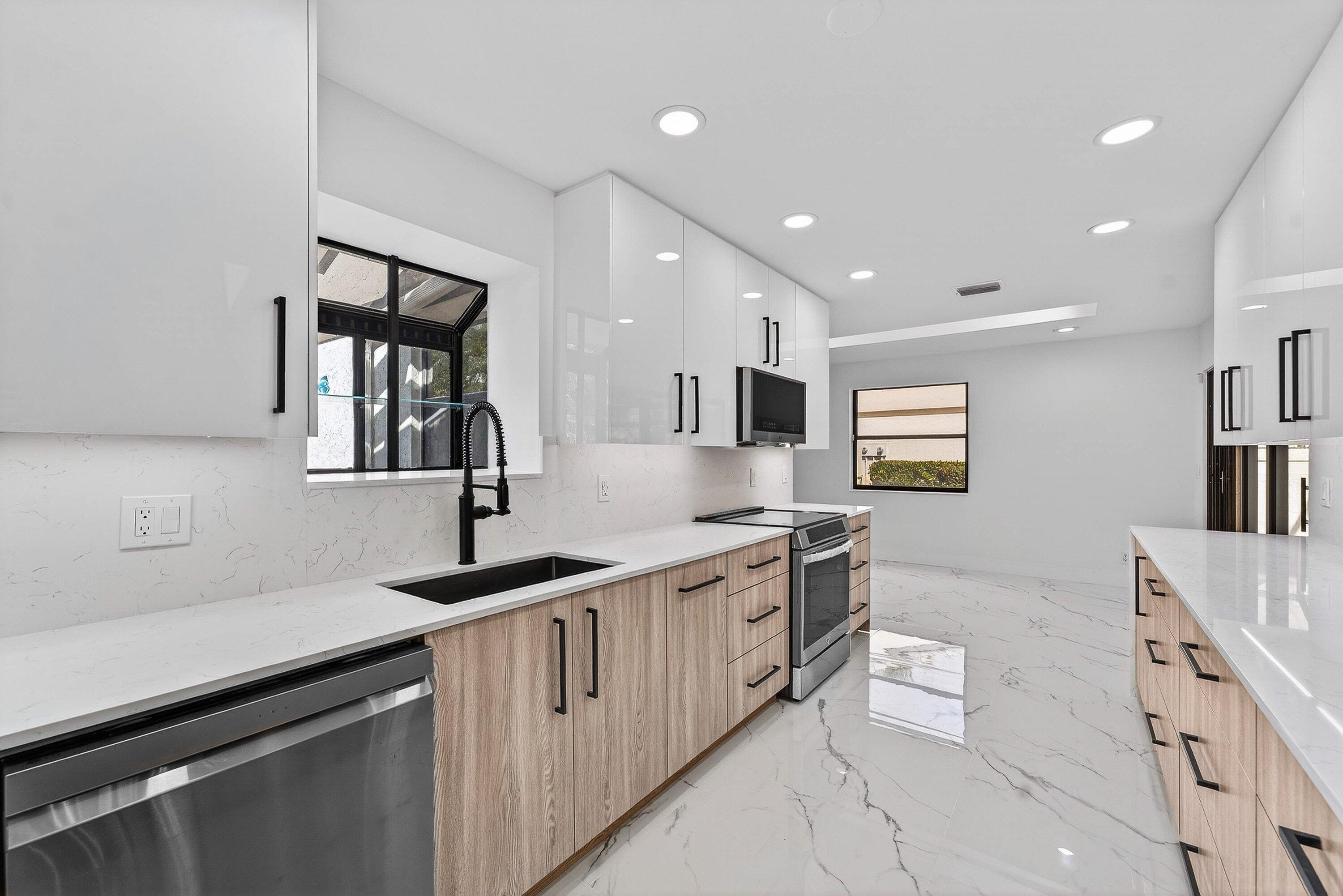 6 Clubhouse Lane Boynton Beach, FL 33436 - Photo 25 of 76 a kitchen with stainless steel appliances granite countertop a sink stove and cabinets