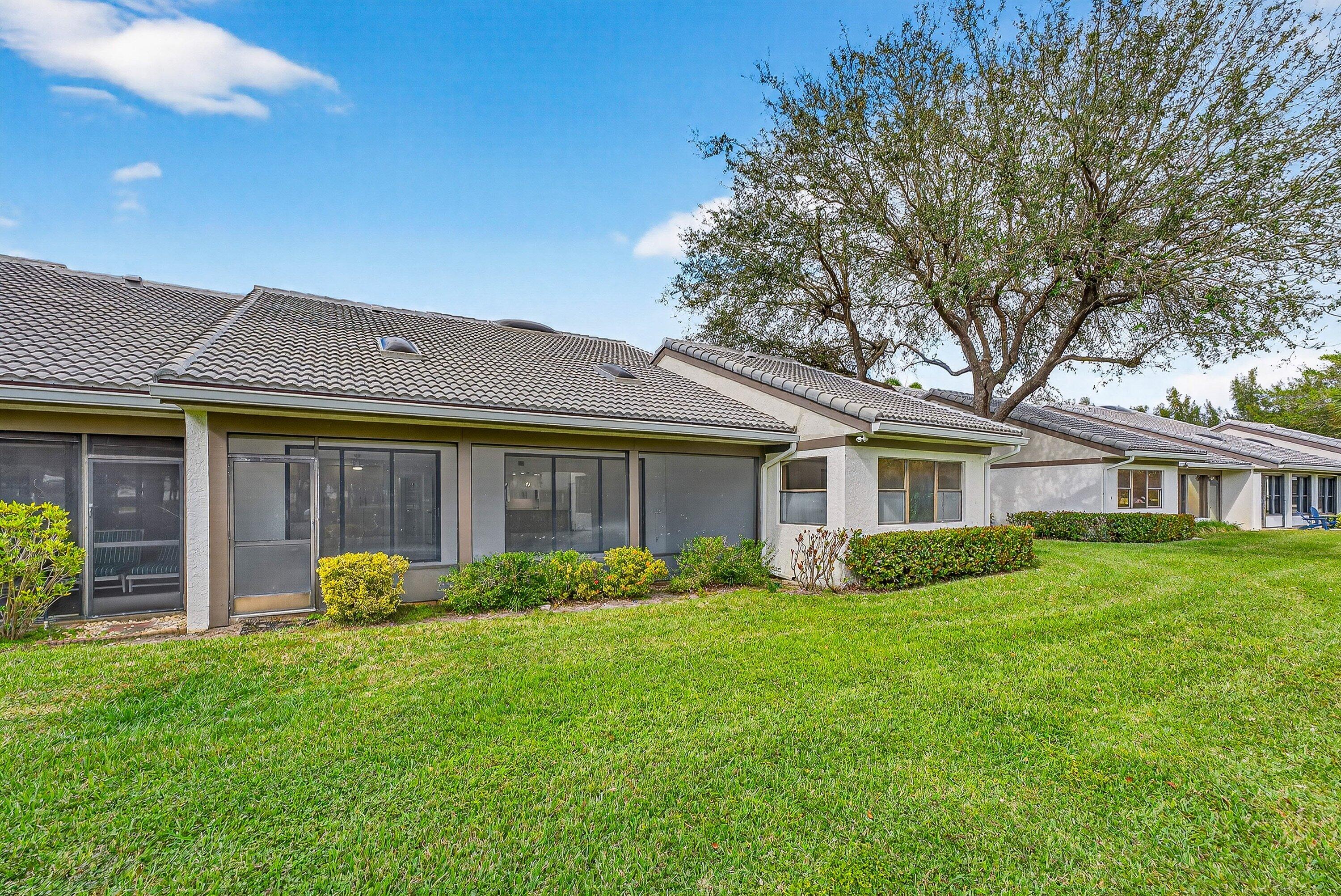 6 Clubhouse Lane Boynton Beach, FL 33436 - Photo 58 of 76 a front view of a house with a garden