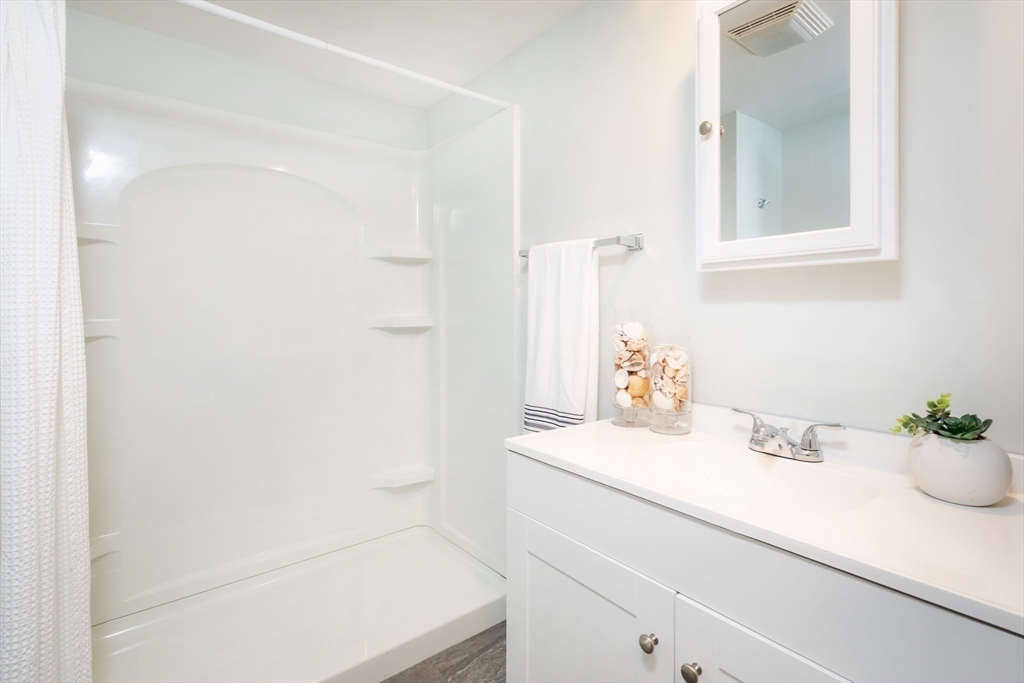 449 Ocean Boulevard, Unit 305 Hampton, NH 03842 - Photo 25 of 28 a bathroom with a sink and a mirror