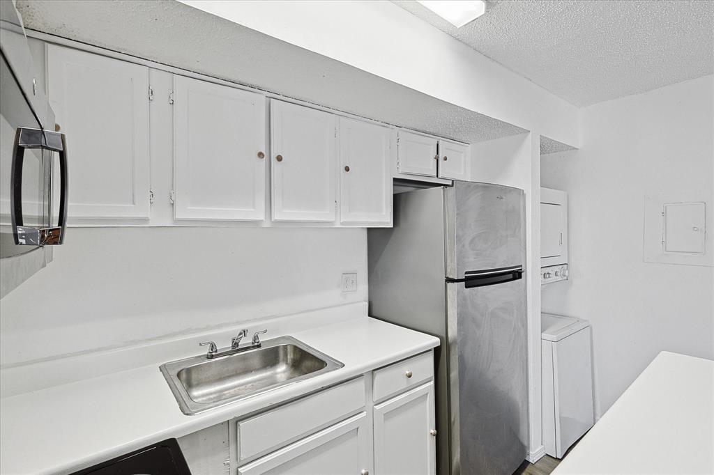 9839 Walnut Street, Unit 306 Dallas, TX 75243 - Photo 11 of 32 a kitchen with refrigerator and cabinets