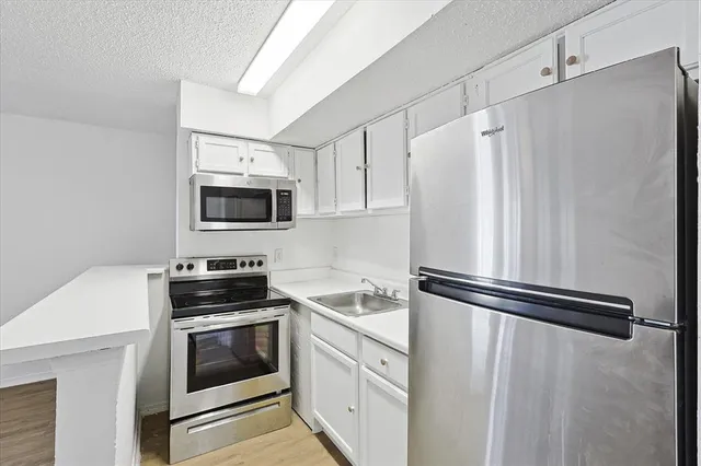a white refrigerator freezer and cabinets in a white cabinet