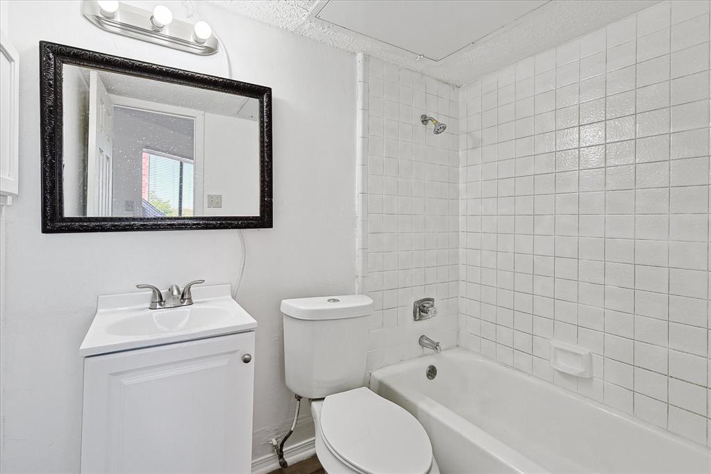 9839 Walnut Street, Unit 306 Dallas, TX 75243 - Photo 18 of 32 a bathroom with a toilet a sink and bathtub