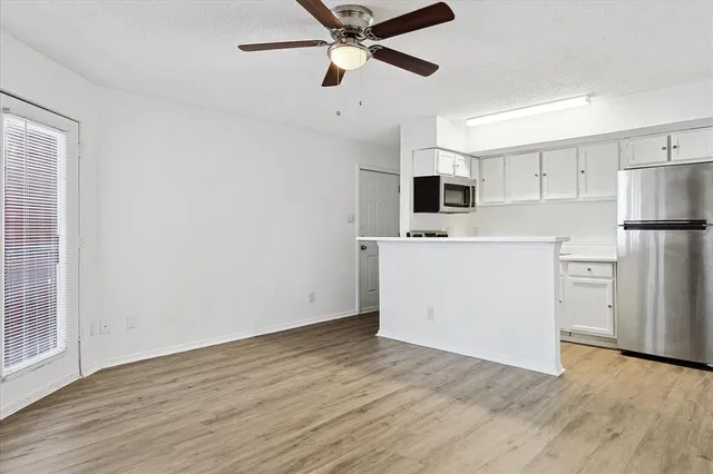 a view of kitchen with wooden floor and electronic appliances