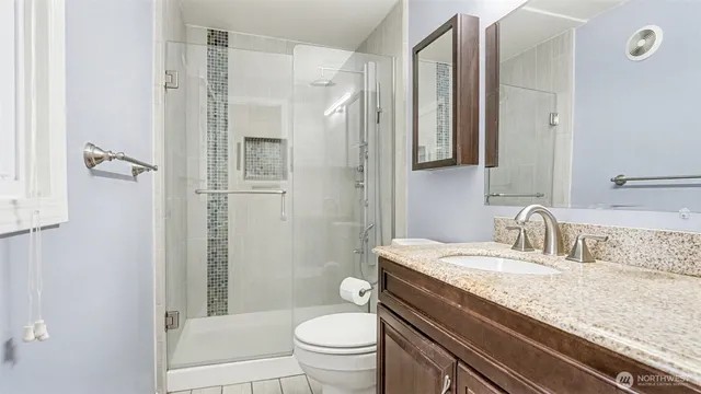 a bathroom with a granite countertop sink toilet and shower