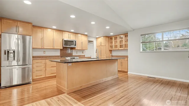 a kitchen with granite countertop a refrigerator and a stove top oven