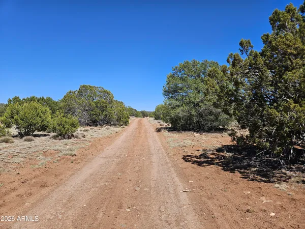 a view of dirt road with a building in the background