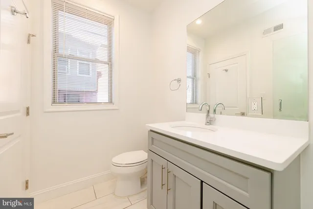 a bathroom with a sink toilet and a mirror