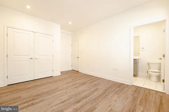 a view of kitchen with kitchen island wooden floor center island and stainless steel appliances