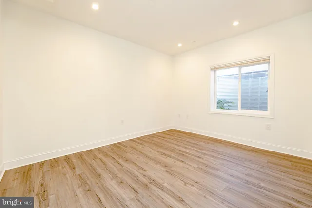 an empty room with a window and wooden floor