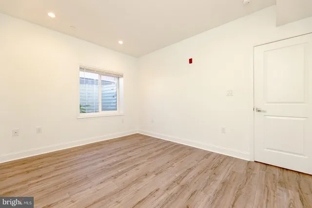 a view of a small space with wooden floor and a window