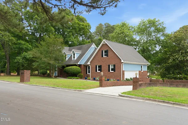 a view of an house with backyard and bushes