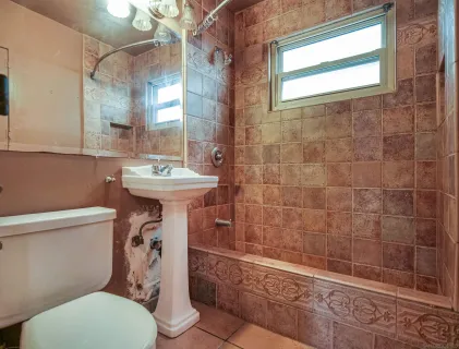 a bathroom with a sink mirror toilet and shower