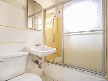 a bathroom with a sink a toilet a mirror and shower