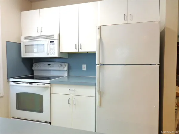 a white refrigerator freezer and a stove sitting inside of a kitchen