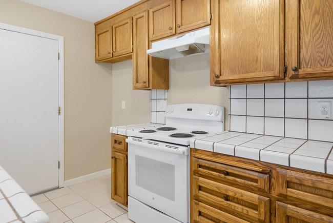 6790 Filbro Drive Gilroy, CA 95020 - Photo 16 of 42 a kitchen with granite countertop white cabinets and white appliances